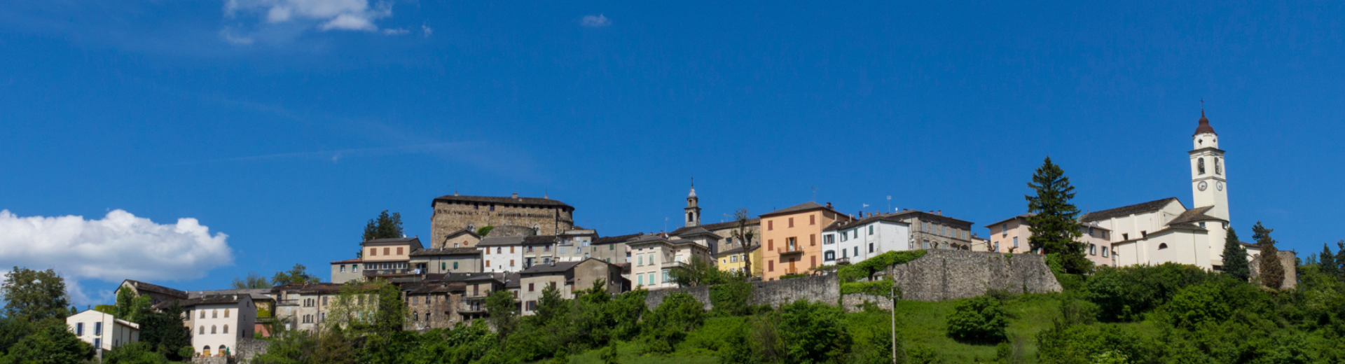Veduta del borgo di Compiano sullo sfondo di cielo azzurro estivo